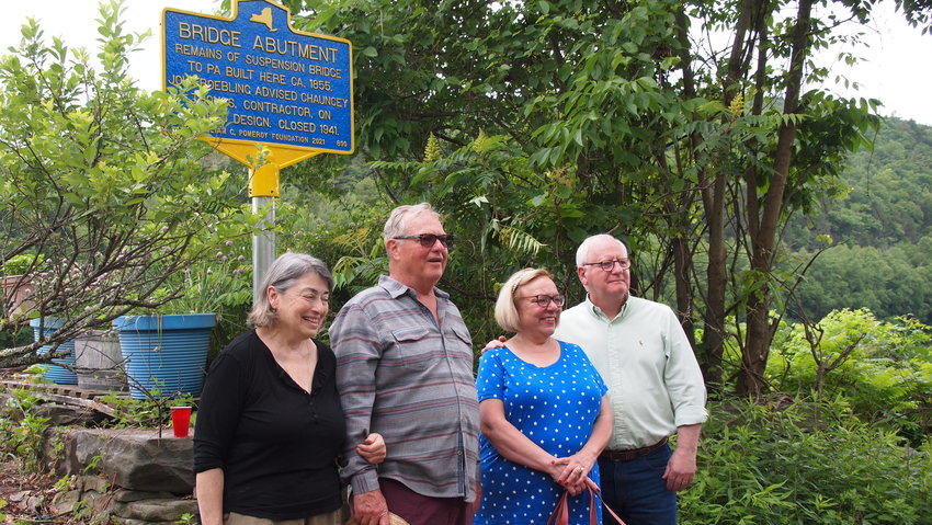 Property owners Leslie Rutkin, left, and Matthew Smith, stand with Town of Highland co-historian Debra Conway and  Sullivan County Historian John Conway in front of the Saturday, June 12 reveal of the third historical plaque in the Town of Highland. The Conways worked with the William G. Pomeroy Foundation to produce the marker, which credits John A. Roebling as assisting in the design of the original 1855 suspension bridge that connected Shohola, PA with Barryville, NY. The marker is located on old bridge abutment on River Road. At the ceremony, John Conway revealed that The Delaware Company, which the Conway's have spearheaded have also signed a contract with Sullivan County to develop the historical programming at Fort Delaware, located in Narrowsburg.